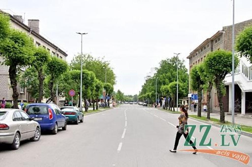 Kā šajā sērijā ierasts, gan vecajā, gan jaunajā attēlā redzam aptuveni vienu un to pašu ielas posmu ar Pasta ielas un Raiņa (agrāk Annas) ielas krustojumu, pie kura celtās pasta ēkas visos laikos devušas ielai tās nosaukumu.
Vecajā attēlā...